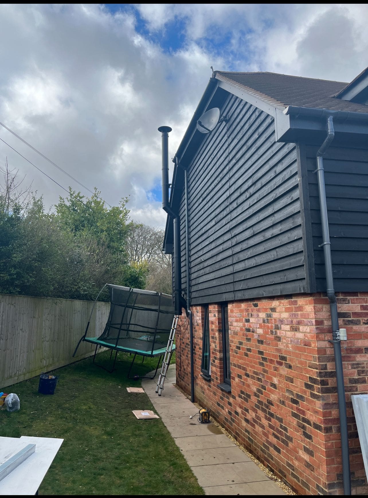 Modern house with black cladding and chimney flute